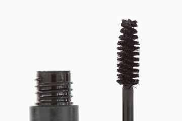 Close up of a black tube and brush of mascara