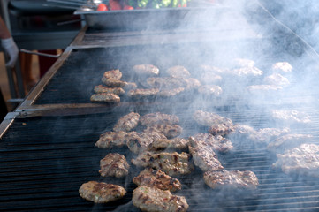 Grilled meatballs on barbecue smoking.