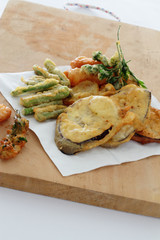 Fried vegetables in batter on a chopping board