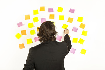 young businessman with postit reminder notes on the background