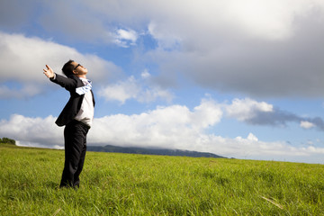 young man in green field under blue skies