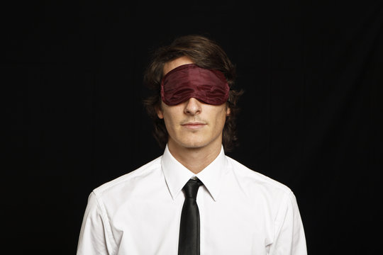 young businessman with eyes covered by sleep mask