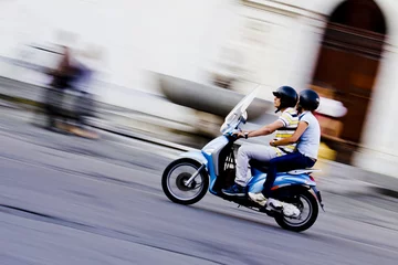Foto op Plexiglas Scooter in movimento con due ragazzi © caprasilana