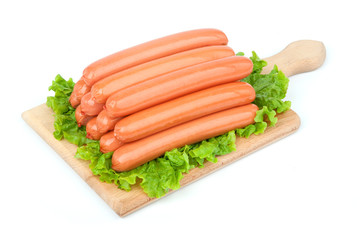 Sausages arranged on cutting board with lettuce