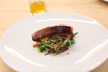 Grilled salmon fillet on soba noodles with pine nuts