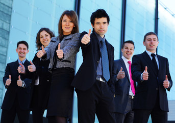 A business team in formal clothes holding thumbs up