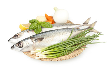 fresh sardines on a plate with vegetables
