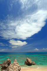 コマカ島の澄んだ珊瑚礁の海と大きな白い雲