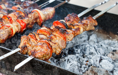 Juicy slices of meat with sauce prepare on fire (shish kebab)