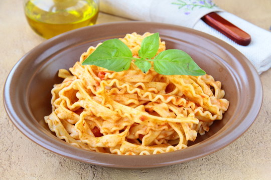 Italian pasta tripoline with tomato sauce and basil