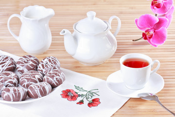 Cup of tea, teapot and chocolate iced spice cakes