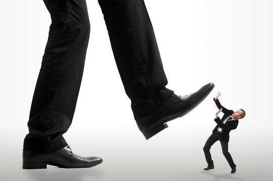 Homme d'affaire se faisant &eacute;craser par un g&eacute;ant