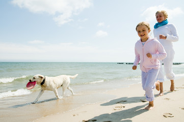 Family with dog playing at the beach