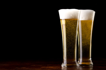 Beer into glass on a black and wooden table