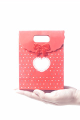 Hand holding red gift bag, isolated on the white background
