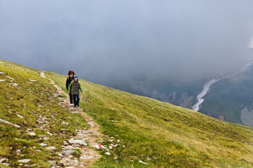 Obraz premium Mother and son hiking into the mountains
