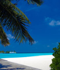 Fototapeta na wymiar Sand beach and ocean vessels, Ari-Atoll. Maldives