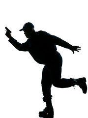 Fototapeta na wymiar Silhouetted police man running with a handgun