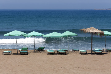 Sun chairs and umbrellas against Mediterranean Sea - Crete