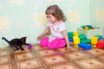The girl plays with a kitten