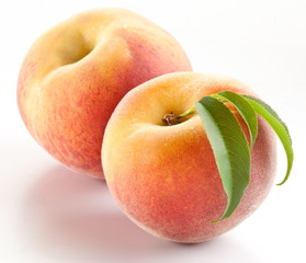 Two ripe peach with leaves