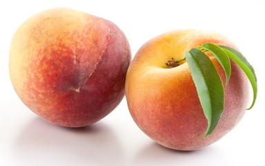 Two ripe peach with leaves