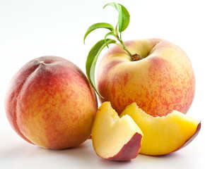 Ripe peach fruit with leaves and slises
