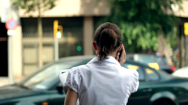 Businesswoman talking on phone,crossing street, steadicam shot