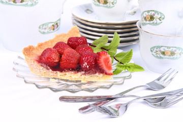 Strawberry tart, mint twig and tableware