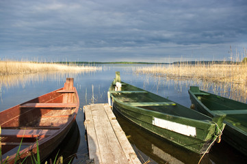 Obraz premium Scene with two boats, lake and pier