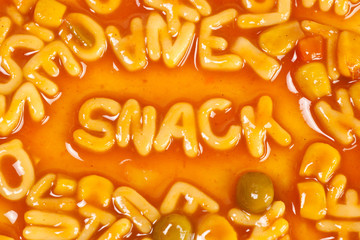 Pasta forming the word SNACK in tomato sauce