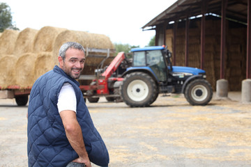 Naklejka premium Famer stood by hay barn
