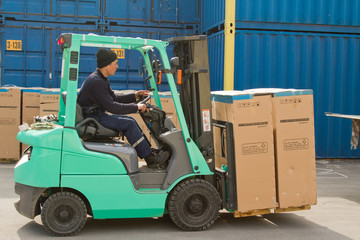 worker carries a box on the  truck