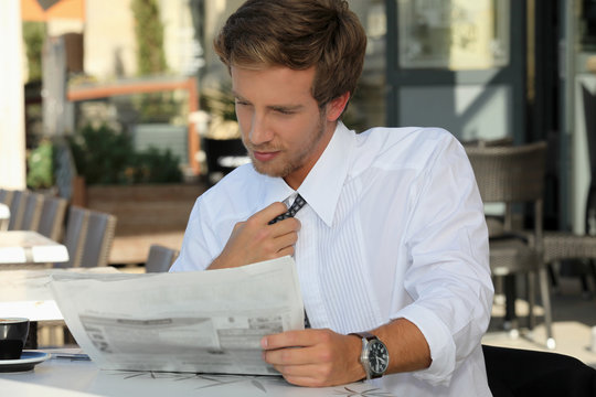 Young Man Relaxing Reading Newspaper