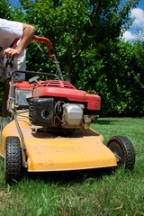 Homme r&eacute;glant la tondeuse