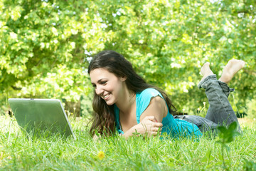 beautiful young woman using laptop outdoors