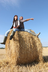 Farmer and wife sat on hay roll © auremar