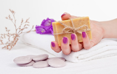 Fototapeta na wymiar Aromatherapy: hand with manicure holding herbal soap