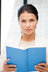 calm and serious woman with book