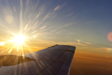 Obraz na płótnie Canvas Zachód słońca nad skrzydłem samolotu z romantycznymi niebie