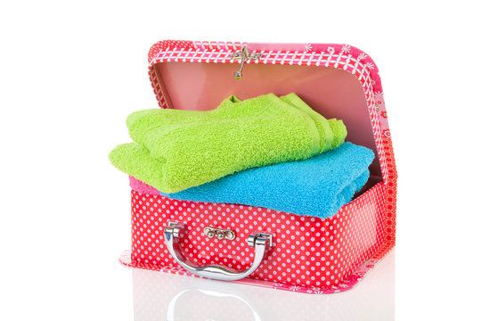 Suitcase and towels over white background