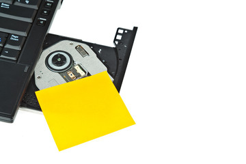 close up of a dvd in a laptop tray and post-it