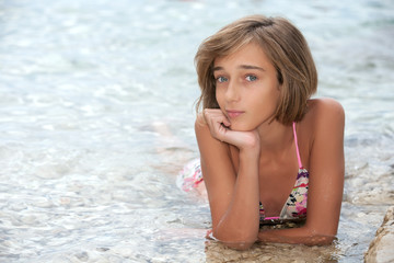 Teenage girl laying in the sea water