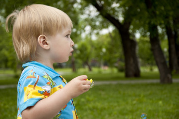 The boy blows soap bubbles