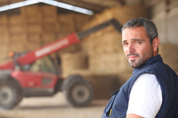 farmer posing in front of a tractor