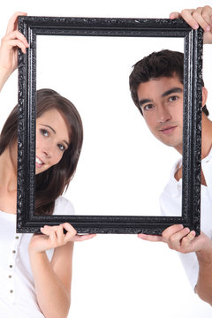 Man And Woman Holding Up A Picture Frame