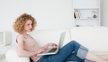 Fototapeta premium Beautiful blonde woman relaxing with her laptop while sitting on