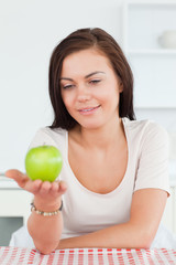 Smiling brunette showing an apple