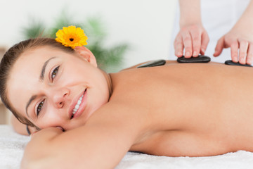 Obraz na płótnie Canvas Charming woman having a hot stone massage
