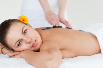 Obraz na płótnie Canvas Close up of a delighted woman having a hot stone massage